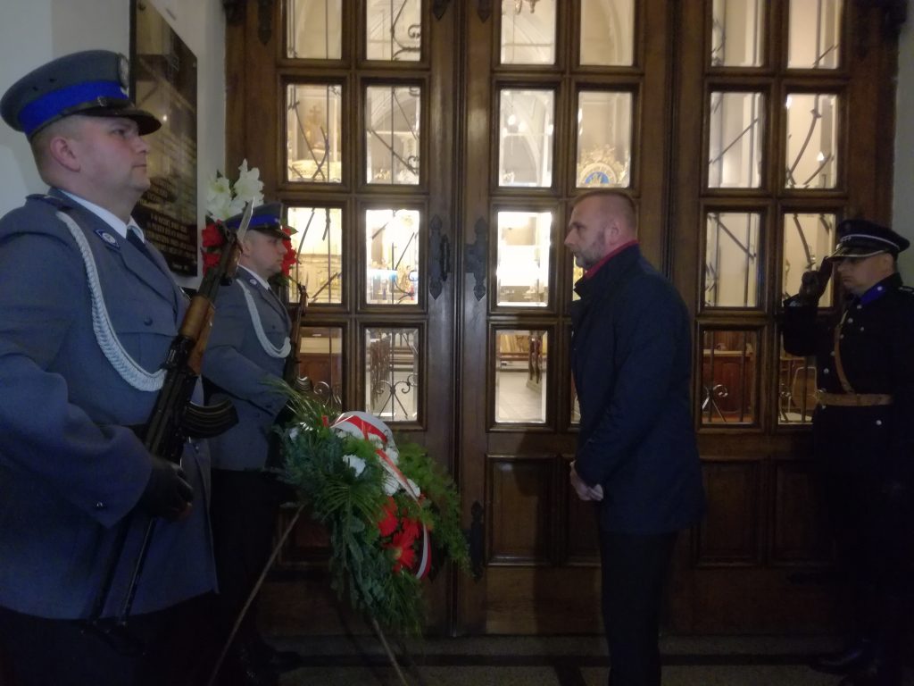 Zastepca prezydenta Oświęcima składa kwiaty przy tablicy upamiętniającej zamordowanych 