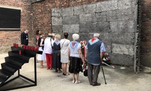 Byli więźniowie KL Auschwitz składają kwiaty pod Ścianą Śmierci