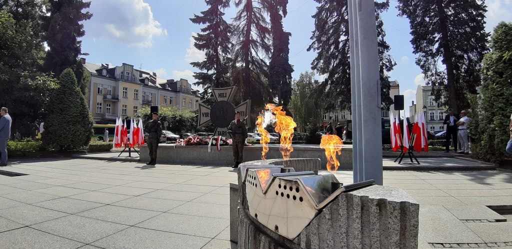 Grób Nieznanego Żołnierza z zapalonymi zniczami i udekorowany flagami
