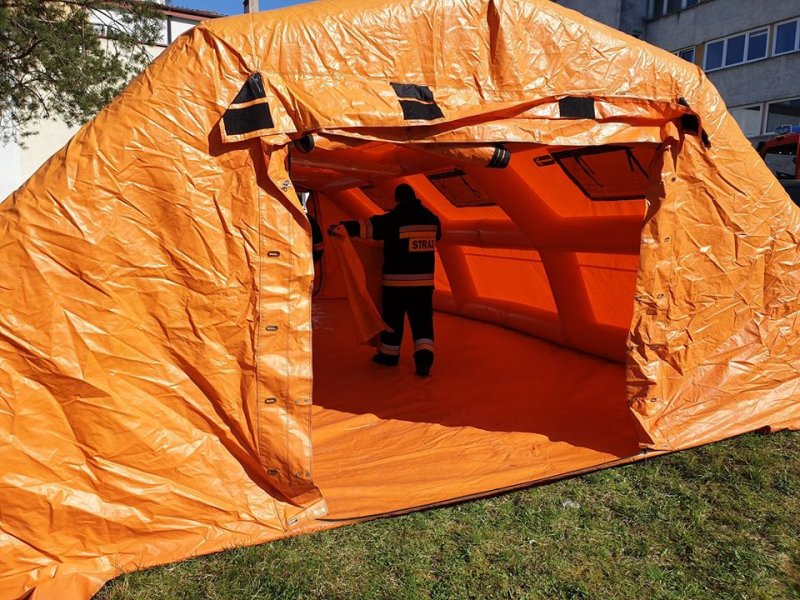 Strażacy rozkładają namiot przed szpitalem do segregacji pacjentów