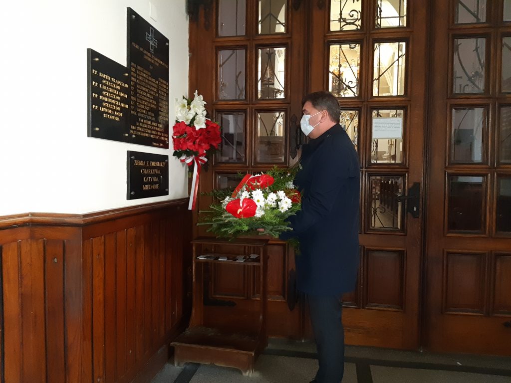 Prezydent Oświęcimia przed tablicą  w kościele oddaje hołd ofiarom zbrodni na polskich jeńcach wojennych