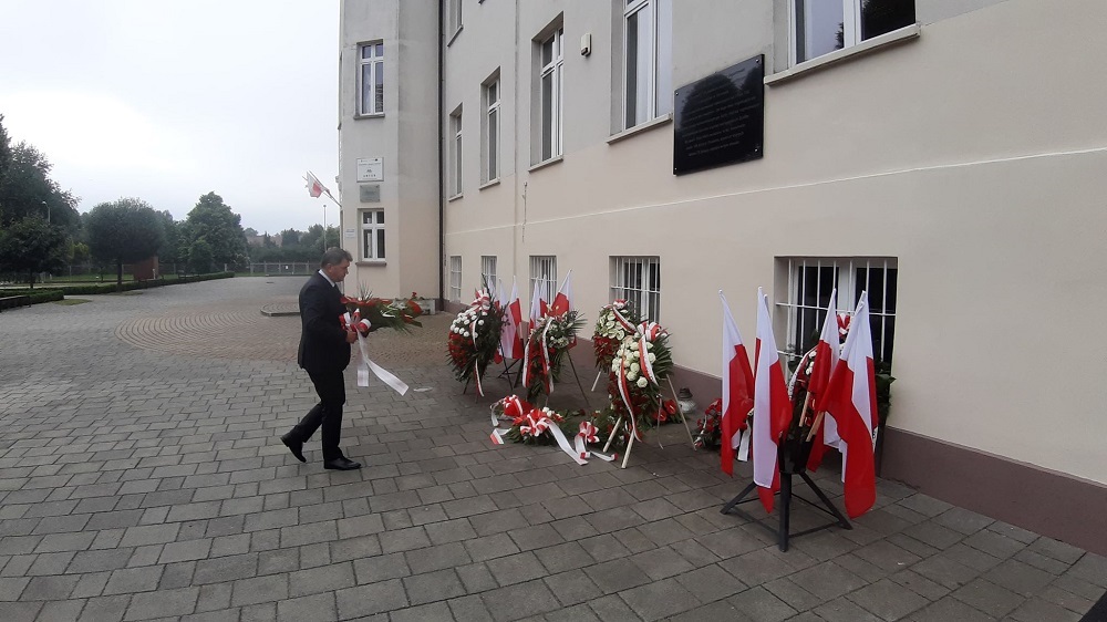 Prezydent Oświęcimia Janusz Chwierut składa kwiaty przy tablicy upamiętniającej przybycie I transportu Polaków znajdującej się na budynku Małopolskiej Uczelni Państwowej
