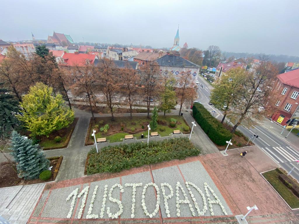 Na placu Kościuszki ułożono z białych chryzantem napis 11 listopada. Widok z góry