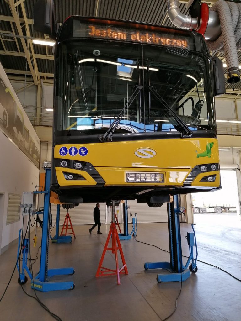 Autobus elektryczny na podnośniku w fabryce