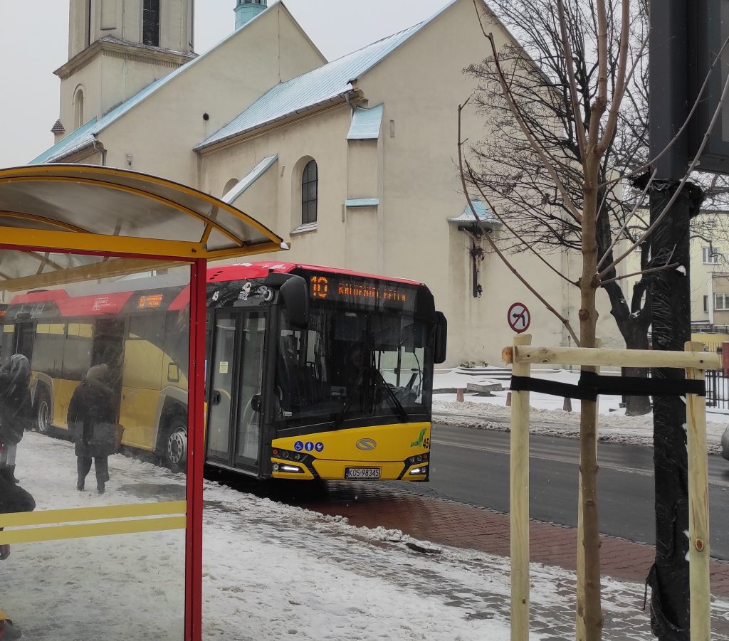 Autobus komunikacji miejskiej podjeżdża na przystanek autobusowy znajdujący się na wprost kościoła parafialnego