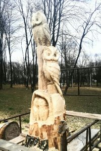 Sowy wyrzeźbione w starym ściętym pniu drzewa w parku Pokoju
