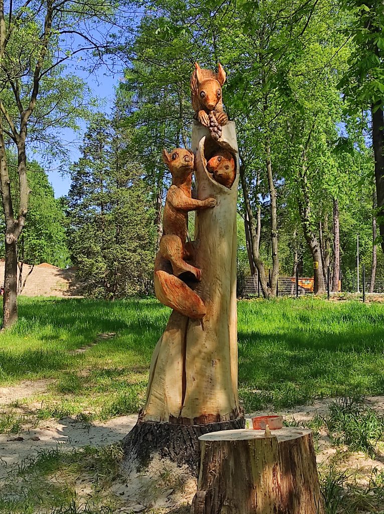 W pniu drzewa wyrzeźbiona rodzina wiewiórek