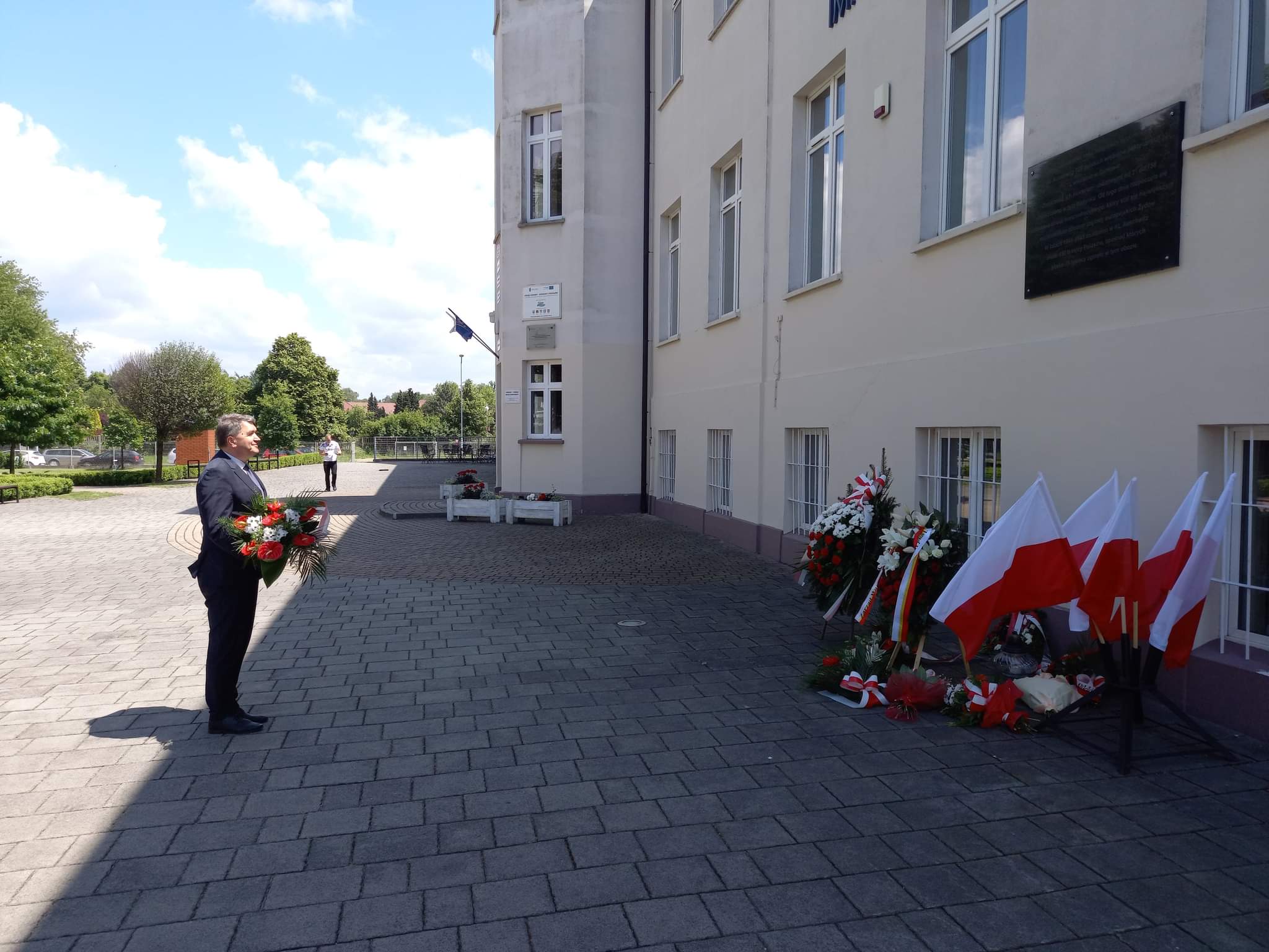 Prezydent składa kwiaty przed tablicą na budynku Małopolskiej Uczelni Państwowej, do którego trafili więźniowie z pierwszego transportu