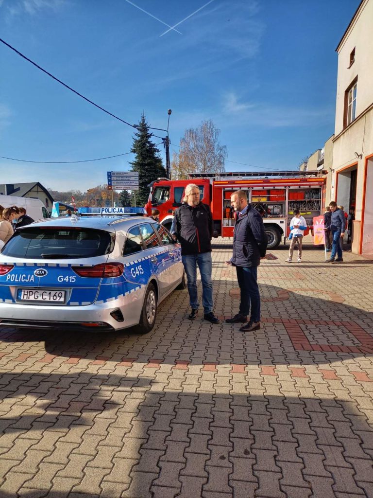 Wiceprezydent Krzysztof Kania stoi wraz z policjantem koordynującym akcję sprawdzania trzeźwości przy radiowozie