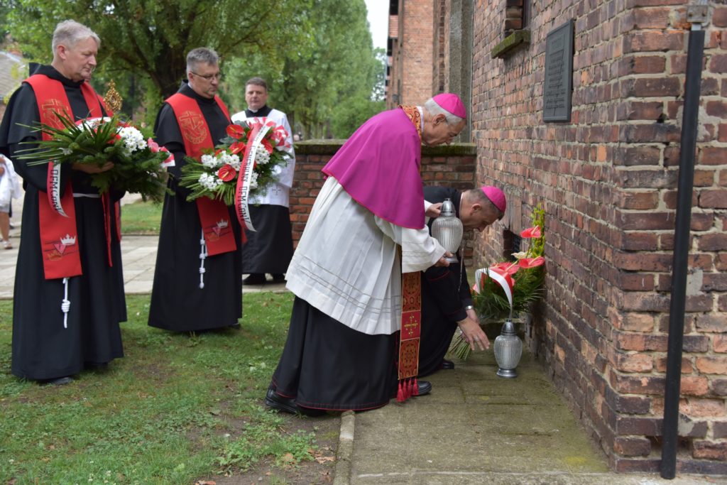 Biskup składa kwiaty