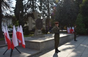 Przed Grobem Nieznanego Żołnierza stoi warta honorowa, obok na stojaku są flagi biało-czerwone