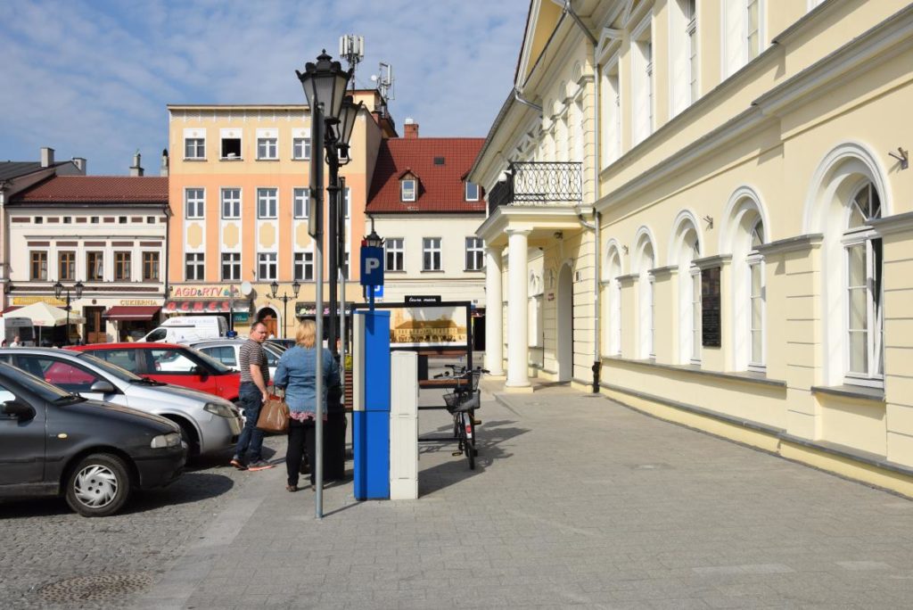 Fragment rynku, na który jest strefa płatnego postoju. Są więc samochody oraz parkomat