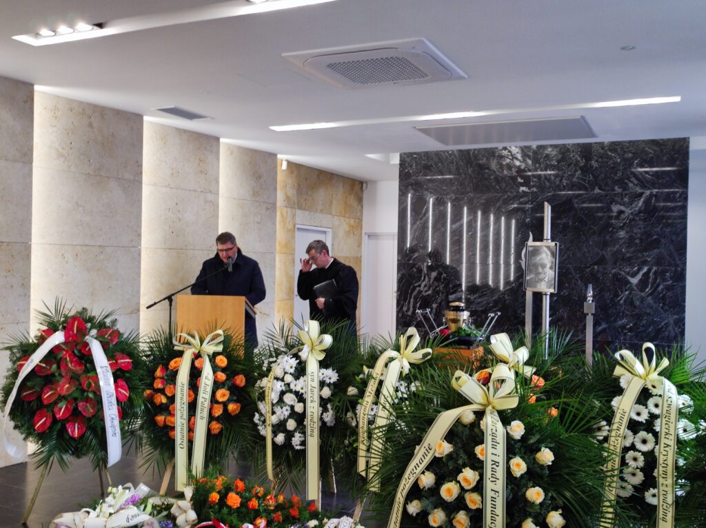 Zdjęcia, urna z prochami i wieńce od żałobników, przemawia prezydent