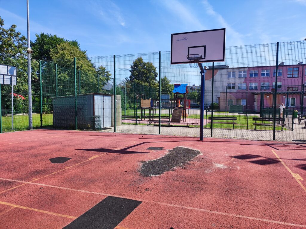 Boisko do piłki koszykowej ze zniszczoną nawierzchnią