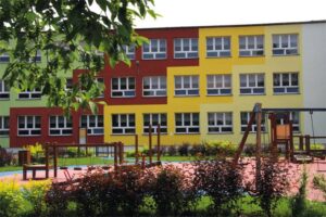 Budynek szkoły wraz z częścią placu zabaw przed budynkiem oraz otaczająca zieleń