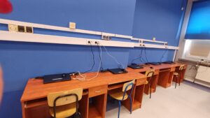 Pracownia sztucznej inteligencji - na biurkach znajdują się czarne laptopy 