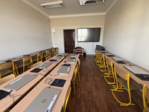 Pracownia sztucznej inteligencji - na biurkach znajdują się srebrne laptopy